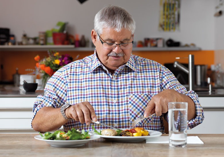 Mahlzeitendienst: Ein Mann am Tisch mit einer gesunden Mahlzeit.