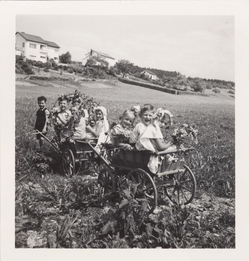Doppelhochzeit: Acht Kinder sitzen in geschmückten Leiterwagen und spielen Hochzeit, um 1943.
