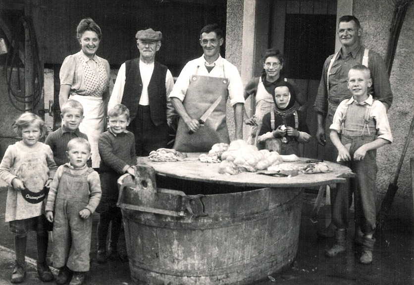 Schwarzweissfoto einer Grossfamilie beim Metzgen um 1951