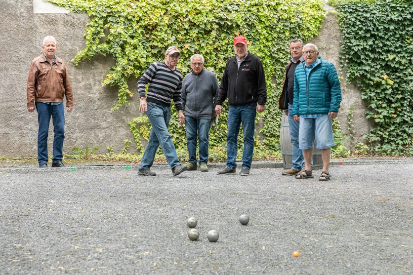 Einen Gruppe von 6 älteren Männern beim Petanque spielen.