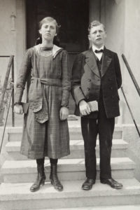 Bramois, Porträt einer jungen Frau und eines jungen Mannes (Jugendliche) vor dem Dienst-Wohngebäude des Elektrizitätswerks. Wallis, ca. 1920