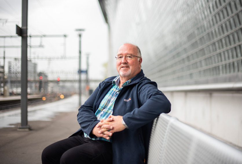 Marcel Steiner, Lokführer SBB, sitzt auf einer Bank auf einem Bahnsteig und schaut in die Kamera.