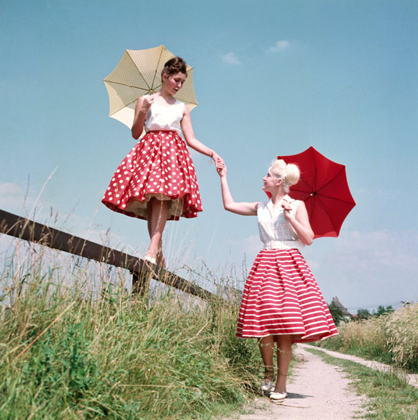 Freundinnen im Petticoat, rot mit weissen Tupfen, mit Sonnenschirmen um 1955