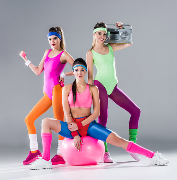 Sportliche Mädchen in neonfarbigen Leggins posieren mit Radiogerät.