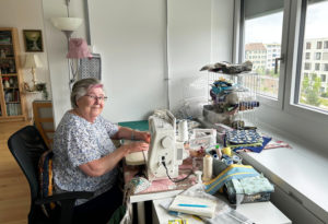 Dorothy Aellan in ihrer Wohnung an der Nähmaschine.