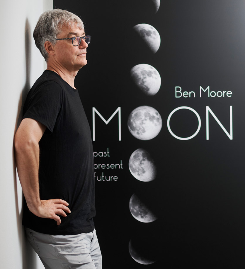 Astrophysiker Ben Moore vor einem Mond-Plakat