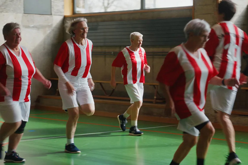 Szene aus "Kick it like Trudi": ehemalige Fussballerinnen trainieren im Trikot in einer Turnhalle.