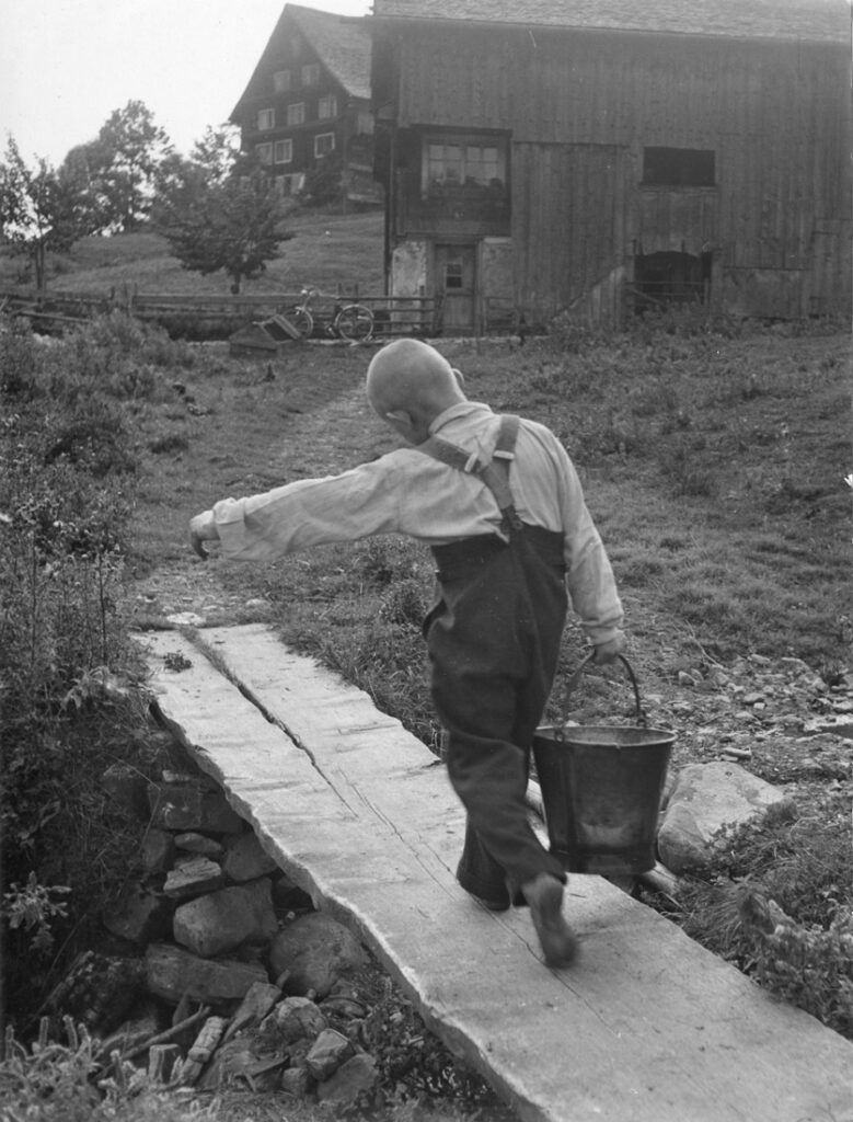 Arbeitende Kinder: Ein Junge schleppt einen Wassereimer