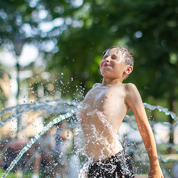 Küchenkniff Wasserspray: ein Junge im Springbrunnen 